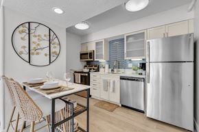 Jacksonville apartment for rent - a kitchen with stainless steel appliances and a table with chairs at AVIA Lofts on Liberty Ridge Apartments, Jacksonville, FL