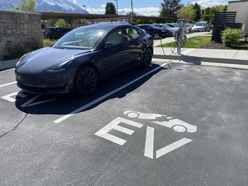 A tesla car is charging at a station.