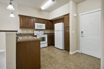 A kitchen with white appliances and wooden cabinets.