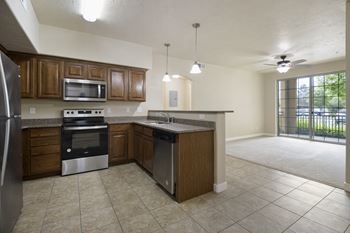 A kitchen with brown cabinets and a black refrigerator.