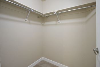 A white wall with a door and a white shelf above it.