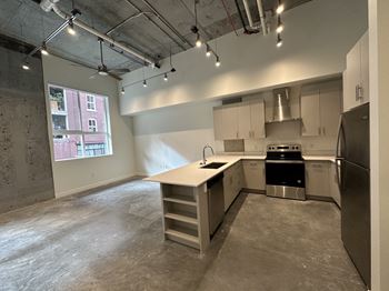 A kitchen area with a stove, sink, and refrigerator.