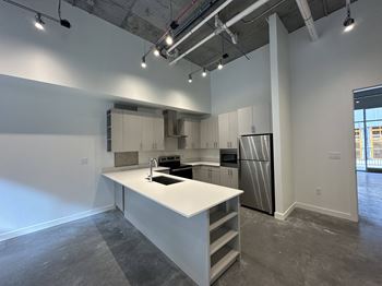 A kitchen with white cabinets and a white island.