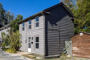 Kingston apartment for rent - A grey house with a brown shed in front of it.