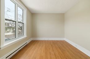 Kingston apartment for rent - Empty room with wooden floor and white walls.