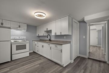 Kingston apartment for rent - A kitchen with white appliances and cabinets.
