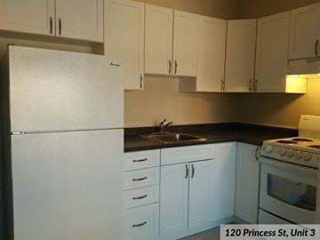 Kingston apartment for rent - an empty kitchen with white cabinets and a white refrigerator
