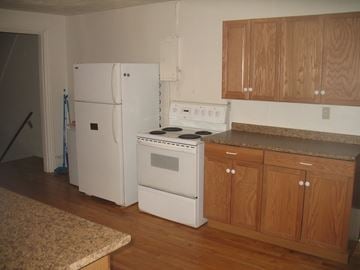 Kingston apartment for rent - a kitchen with white appliances and wooden cabinets