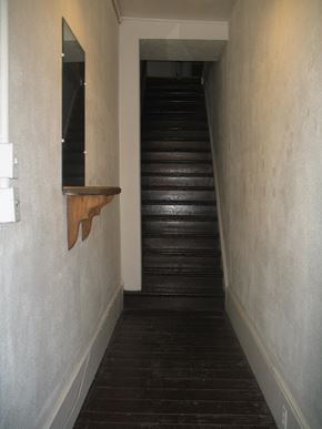 Kingston apartment for rent - a stairwell with a wooden floor and a window on the side of a wall