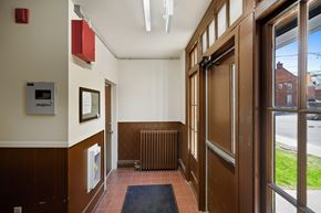 Kingston apartment for rent - A hallway with a brown door and a black mat on the floor.