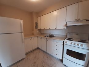Kingston apartment for rent - A kitchen with white appliances and cabinets.