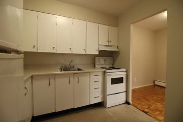 Kingston apartment for rent - A kitchen with white cabinets and a sink.