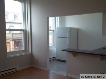 Gananoque apartment for rent - A kitchen with a refrigerator and a window.