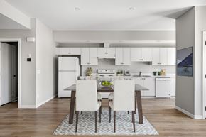 Cochrane apartment for rent - a kitchen and dining room with white cabinets and a table and chairs