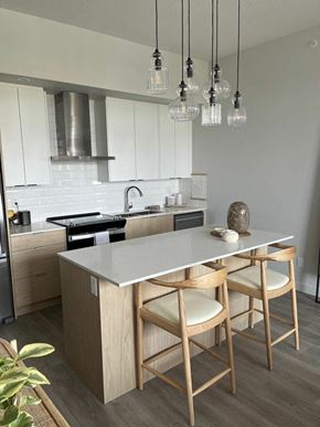 Calgary apartment for rent - a kitchen with a center island next to a stove top oven