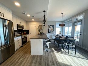 Calgary townhouse for rent - a kitchen with a large island and a table with chairs