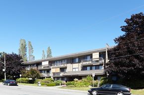 White Rock apartment for rent - a large apartment building with cars parked in front of it