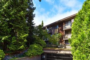 White Rock apartment for rent - a picture of an apartment building with trees in the foreground and a blue sky in the background