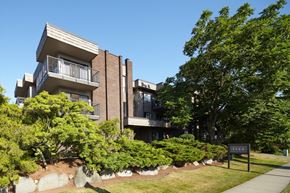 North Vancouver apartment for rent - an apartment building on a sunny day with a sign in front of it