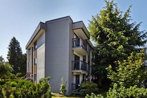 Burnaby apartment for rent - a picture of a gray apartment building with a blue sky in the background