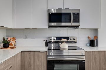 Calgary apartment for rent - A modern kitchen with a stainless steel oven and microwave above it.