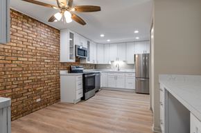 Downers Grove apartment for rent - A kitchen with a brick wall and wooden floors.