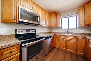 Darien apartment for rent - A kitchen with wooden cabinets and a granite countertop.