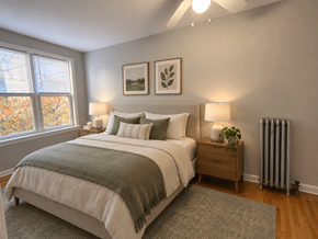 Chicago apartment for rent - A bedroom with a bed, nightstand, and window.