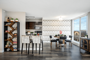 Chicago apartment for rent - A modern dining room with a chevron patterned wallpaper and a wooden dining table set with chairs at The Bryn - 5600 N Sheridan Rd Apartments, Illinois