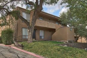 San Antonio apartment for rent - A brown house with a tree in front of it.