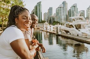 Vancouver apartment for rent - Two people are standing by the water with boats and buildings in the background.