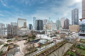 Vancouver apartment for rent - A cityscape with a mix of modern and older buildings, a park area, and a clear sky.