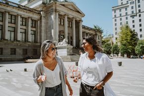 Vancouver apartment for rent - Two women walking and talking in front of a building.