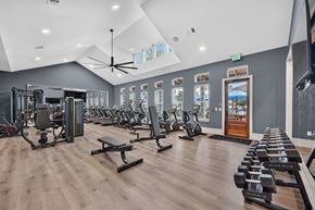 Ponte Vedra apartment for rent - A gym with a variety of equipment including treadmills, weights, and a bench press. Large well lit room with a fan and tvs