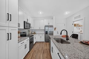 Ponte Vedra apartment for rent - A modern kitchen with white cabinets and a granite countertop.