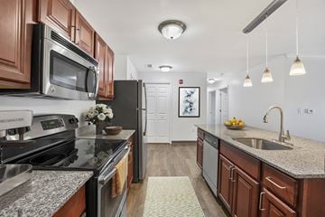 Glenmont apartment for rent - A kitchen with dark wood cabinets and granite countertops.