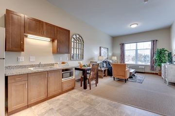 Reno apartment for rent - A kitchen with wooden cabinets and a dining table with chairs.