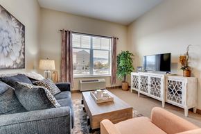 Reno apartment for rent - A living room with a grey couch, a wooden coffee table, and a flat screen TV.