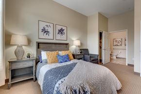 Reno apartment for rent - A bedroom with a large bed and a nightstand with a lamp.