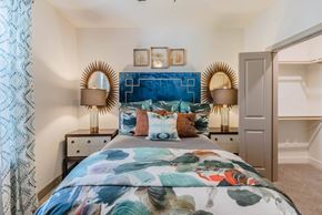 Carrollton apartment for rent - A bedroom with a large bed and a blue headboard at Atlas Point at Prestonwood Apartments , Carrollton, Texas