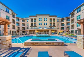Carrollton apartment for rent - A large swimming pool in front of a multi-story apartment building. at Atlas Point at Prestonwood Apartments , Carrollton, Texas