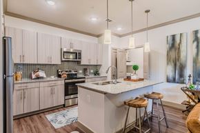 Carrollton apartment for rent - A kitchen with a white countertop and wooden floors. at Atlas Point at Prestonwood Apartments , Carrollton, 75010