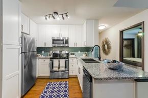 Denton townhouse for rent - A modern kitchen with a granite countertop and stainless steel appliances.