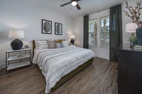 Ponte Vedra apartment for rent - A bedroom with a bed, nightstand, and a ceiling fan. at Atwater at Nocatee Apartments, Florida
