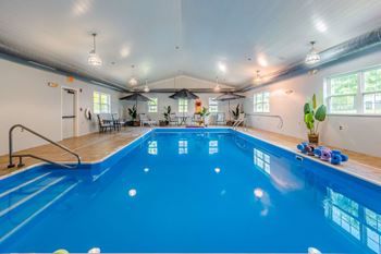 Indoor pool with exercise equipment and lounge chairs