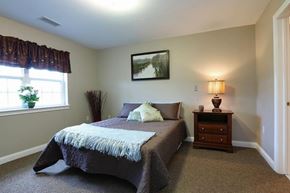 Utica apartment for rent - Cozy bedroom with decorative throw pillows at Schuyler Commons Apartments, Utica, 13502