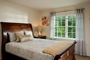 Glenmont apartment for rent - Master bedroom with dark wood sleigh bed at Glenmont Abbey Village, 55+ Apartments, Glenmont, 12077