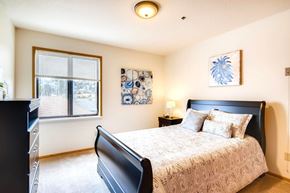King City apartment for rent - A bedroom with a large bed and a window with blinds. at King City Senior Village Apartments, King City