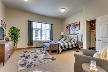 Reno apartment for rent - A bedroom with a large bed and a window with curtains.