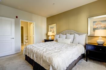 Master bedroom with upholstered headboard and ensuite bathroom